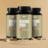 Drei Dosen Ashwa Pure (KSM-66 Ashwagandha) mit 60 Kapseln ruht auf einer beigen Fläche, umgeben von beigen Kapseln und einem kleinen Haufen Granulat, zur Unterstützung der natürlichen Stressresilienz.