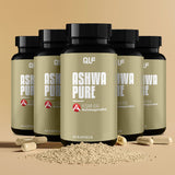 Fuenf Dosen Ashwa Pure (KSM-66 Ashwagandha) mit 60 Kapseln ruht auf einer beigen Fläche, umgeben von beigen Kapseln und einem kleinen Haufen Granulat, zur Unterstützung der natürlichen Stressresilienz.