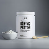 Ein Behälter mit Backprotein steht neben einer Schale mit Pulver und einem Holzlöffel, bereit, Ihren Fitnessrezepten die perfekte Konsistenz zu verleihen - alles vor einem neutralen grauen Hintergrund.