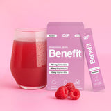 Ein Glas mit rotem Getränk, ein Päckchen und eine Benefit Hydration Box stehen auf einer rosa Fläche mit Himbeeren. Die Verpackung wirbt für die Elektrolytformel mit Magnesium, die Vitaminmischung und den Hydration Stick für erfrischenden Geschmack.