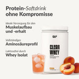 Ein Behälter mit Clear Whey Isolat steht neben einem Glas mit pfirsichfarbenem, proteinreichem Getränk mit Eis und frischen Pfirsichscheiben. Der deutsche Text hebt die Vorteile für den Muskelaufbau, die Unterstützung einer Diät und die Tatsache hervor, dass das Getränk völlig fettfrei ist.