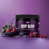 Ein Deep-Sleep-Behälter ruht auf einer violetten Fläche, umgeben von Himbeeren, Lavendelblüten und Minzblättern - und präsentiert innovative Nährstoffe für die Nacht auf einem passenden violetten Hintergrund.