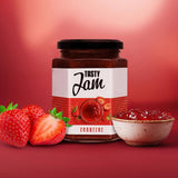 Ein Glas Tasty Jam steht neben zwei frischen Erdbeeren und einer kleinen Schale mit kalorienarmem Fruchtaufstrich vor einem roten Hintergrund mit Farbverlauf.