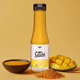 Eine Flasche Tasty Sauce, Geschmacksrichtung Sweet Mango Curry, steht auf einer gelben Fläche, daneben eine Schale mit Sauce, geschnittener Mango und Currypulver - einer idealen kalorienarmen Diätzutat - vor einem leuchtend gelben Hintergrund arrangiert.