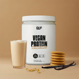 Ein Behälter mit Vegan Protein steht neben einem Glas Proteinshake, Keksen, Vanilleschoten und Kekskrümeln auf einem beigen Hintergrund - ideal für deine vegane Revolution.